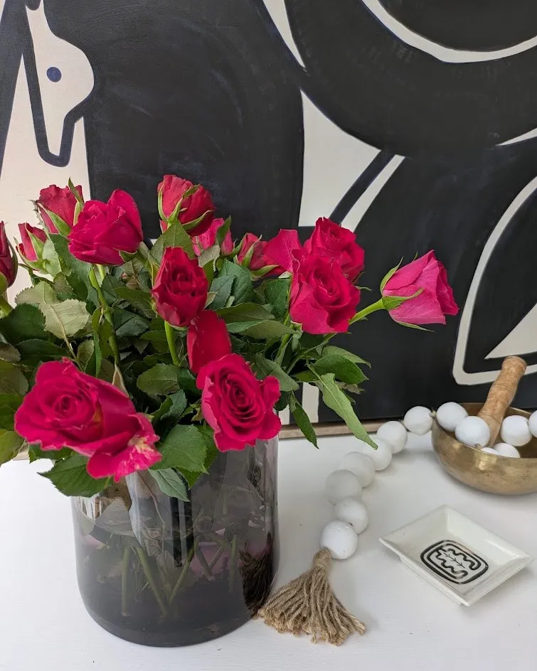 Un bouquet de roses fuchsia devant un tableau graphique noir et blanc